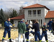 Die THW Helfer errichten einen provisorischen Deich um die angrenzenden Häuser zu schützen.