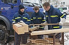 Die Helfer suchen Holz für einen Stapelbau aus.